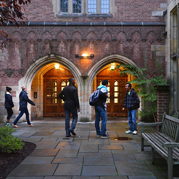Students around arches on Yale's campus.